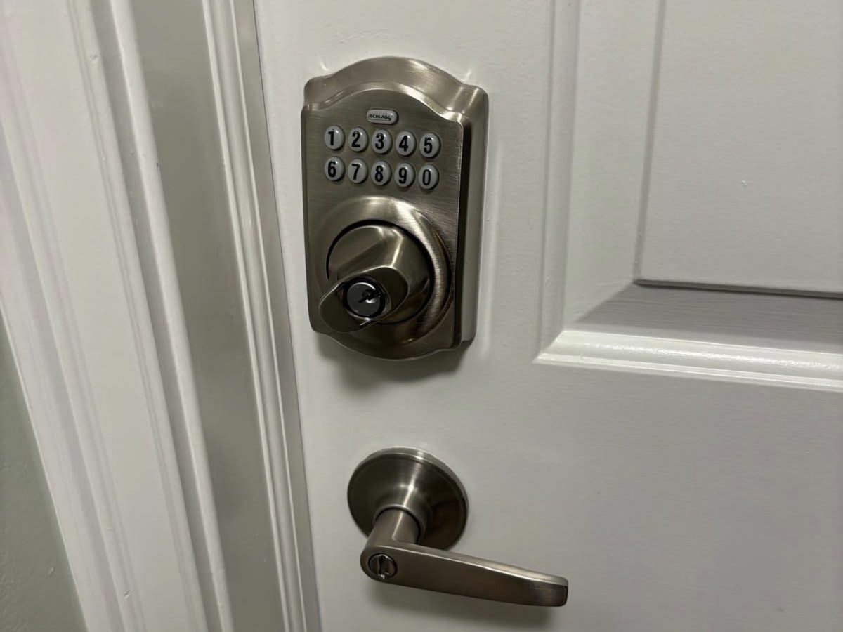 Satin Schlage keypad deadbolt and lever handle on a white door