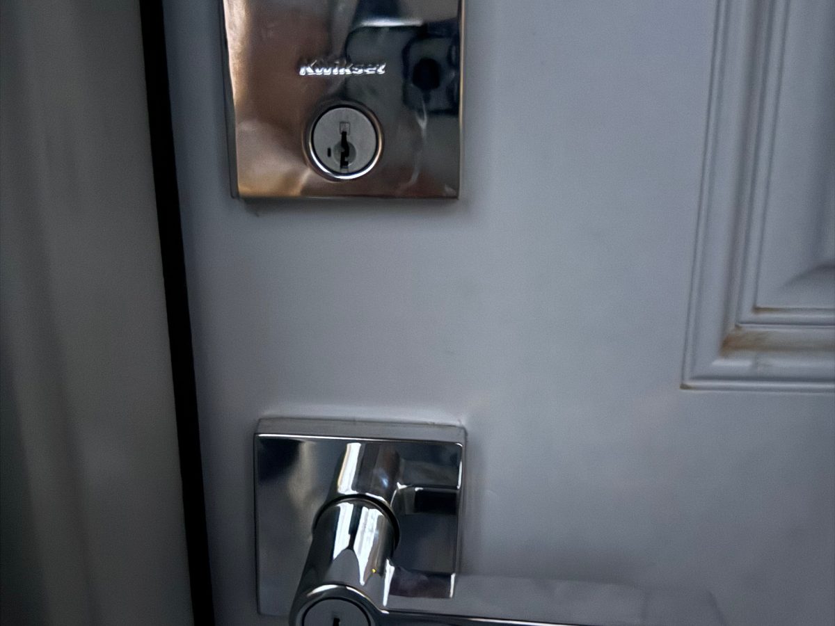 Kwikset deadbolt and lever handle installed on a white entry door