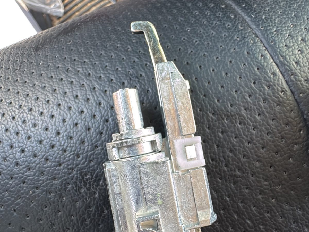 Removed ignition lock cylinder resting on a car seat