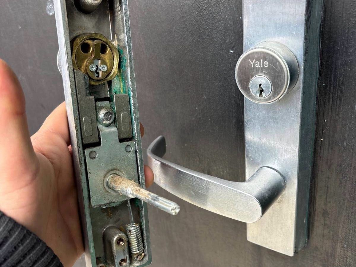 Technician holding an open commercial door lock assembly