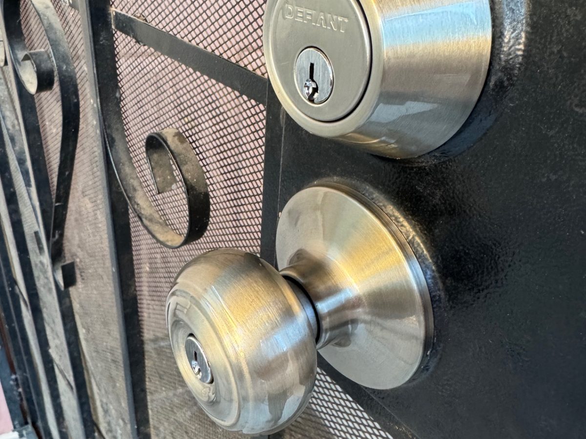 Deadbolt and knob installed on a black metal security gate