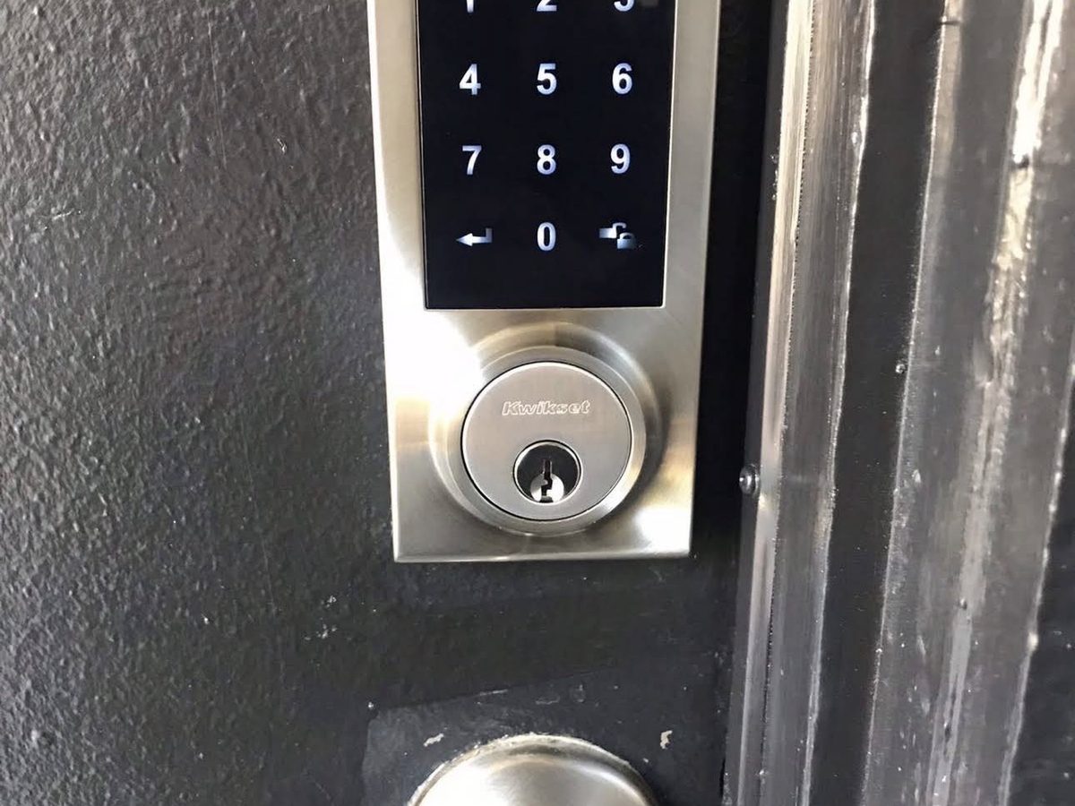 Touchscreen smart lock installed on a black entry door